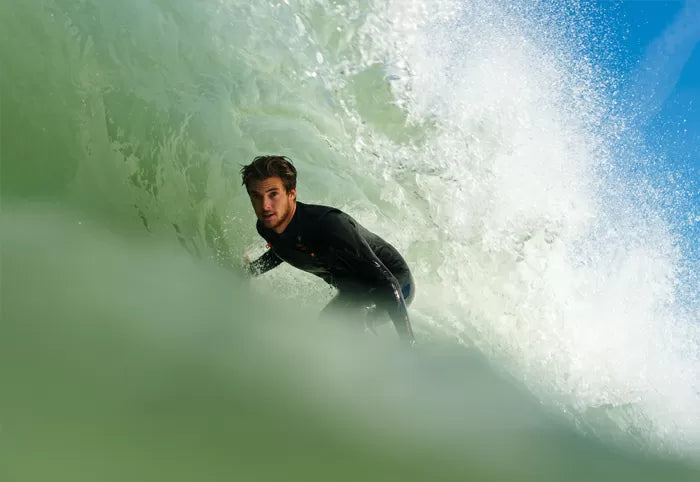 A surfer in a SRFACE Heat wetsuit, skillfully riding inside a barrel