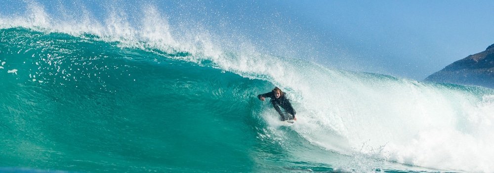 Surfer getting barreled with SRFACE all season spring wetsuit in Cape Town